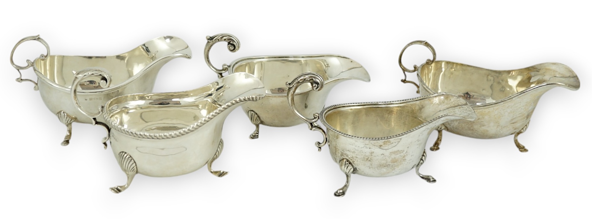 Five assorted early 20th century and later silver sauce boats, various dates and makers, 21.3oz.